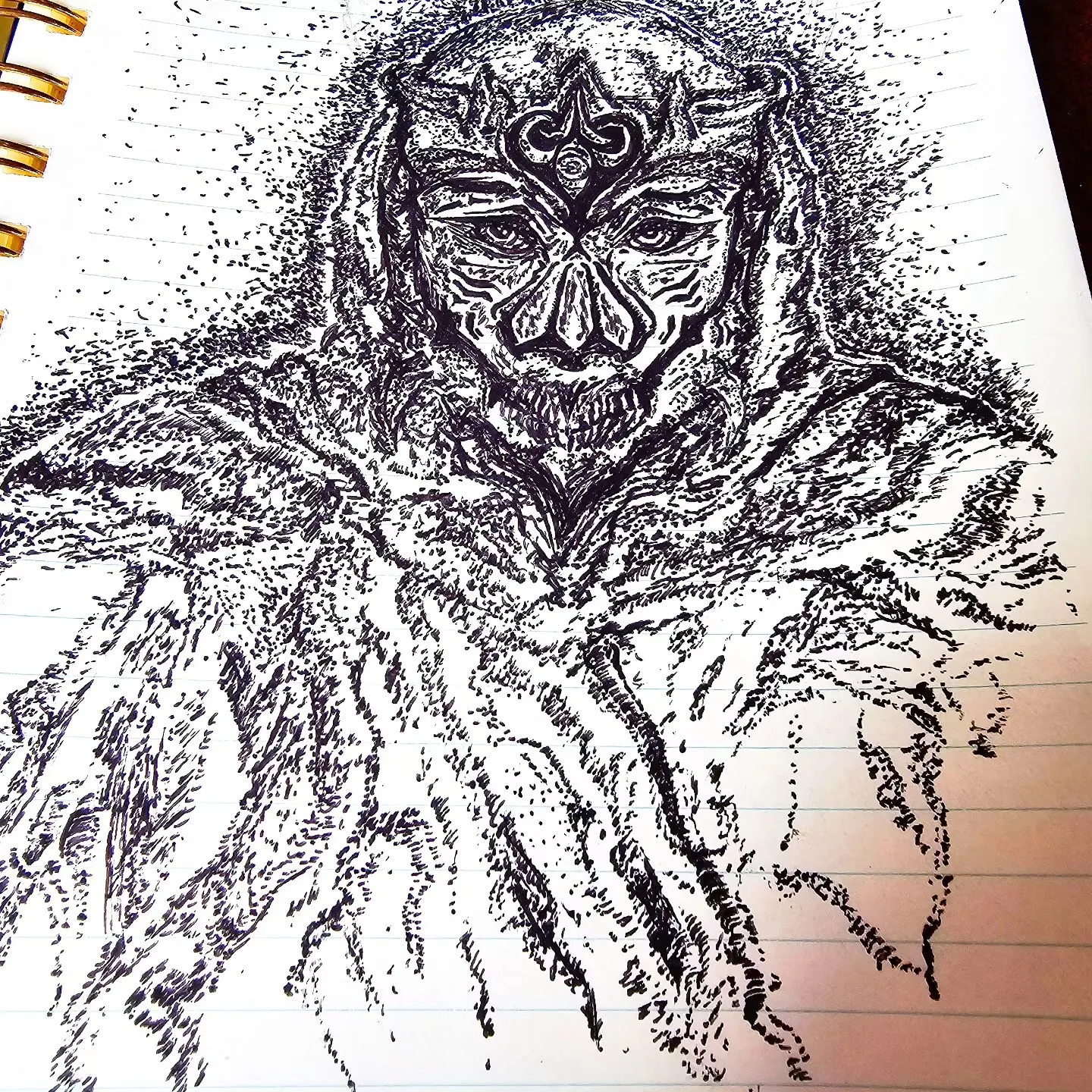 A black ink drawing of a hooded figure wearing an elaborate patterned mask.
