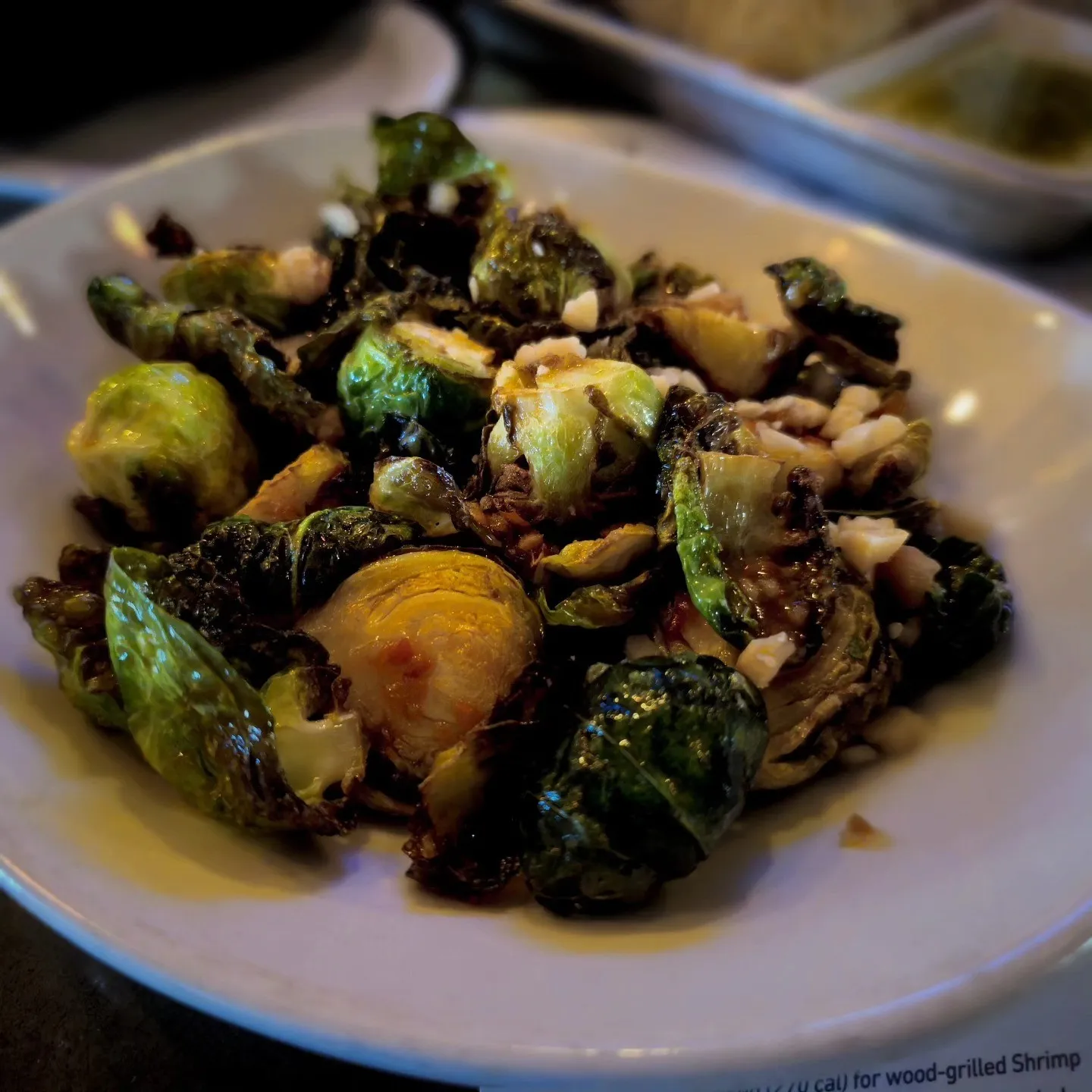 Roasted Brussels sprouts and other vegetables fill a white plate.